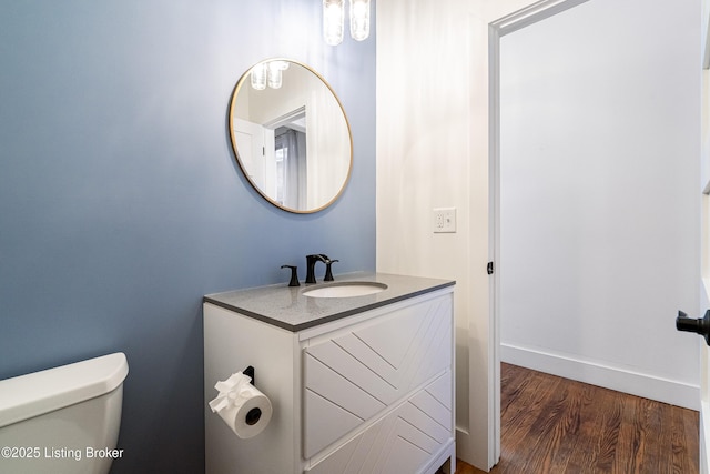 bathroom featuring vanity, wood-type flooring, and toilet