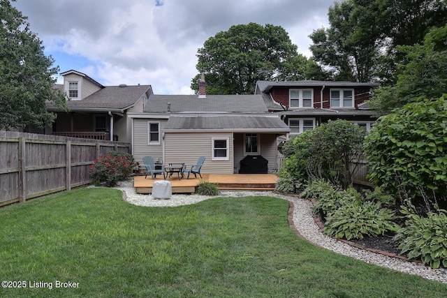 rear view of house featuring a deck and a lawn