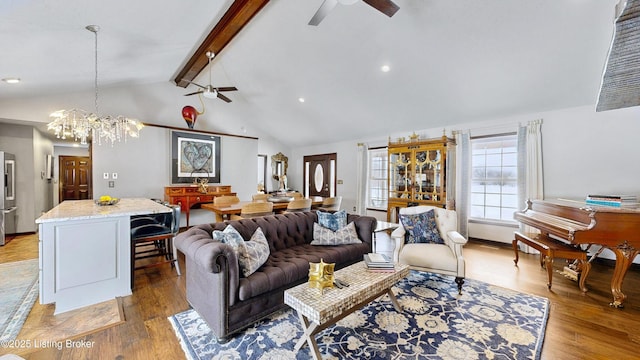 living room with lofted ceiling with beams, ceiling fan with notable chandelier, and wood finished floors