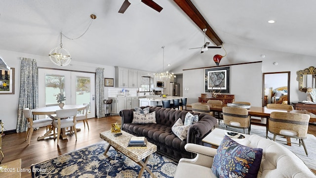 living area with wood finished floors, vaulted ceiling with beams, ceiling fan with notable chandelier, french doors, and recessed lighting