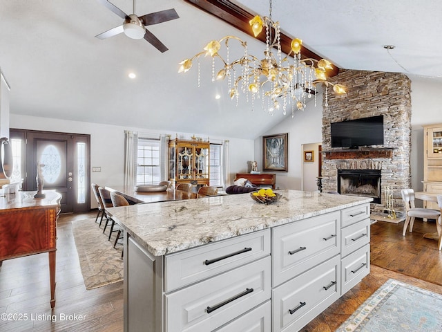 kitchen featuring open floor plan, white cabinets, and hanging light fixtures