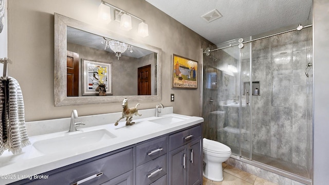 bathroom featuring toilet, a sink, visible vents, and a shower stall