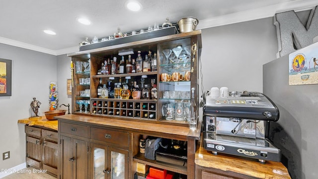 bar featuring baseboards, recessed lighting, bar, and crown molding