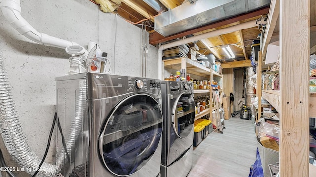 laundry area featuring light wood-type flooring, laundry area, and washing machine and dryer