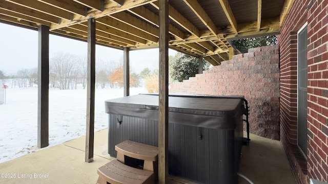 snow covered patio with a hot tub