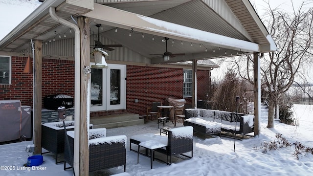 snow covered patio featuring outdoor lounge area, a ceiling fan, and french doors