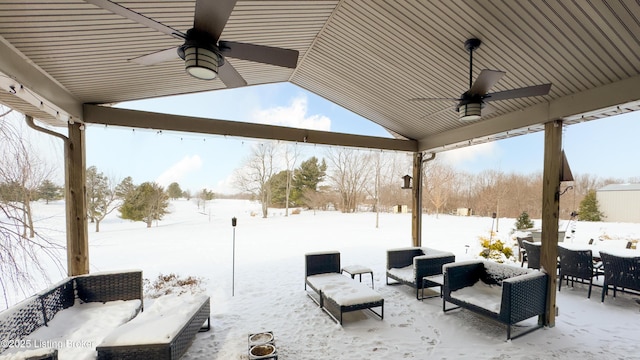 snow covered patio with outdoor lounge area, a ceiling fan, and outdoor dining space