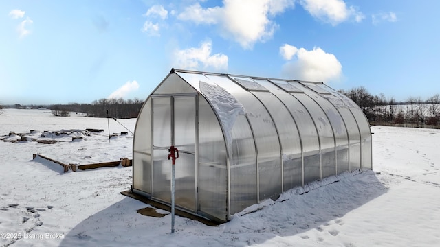 snow covered structure featuring an outdoor structure and an exterior structure