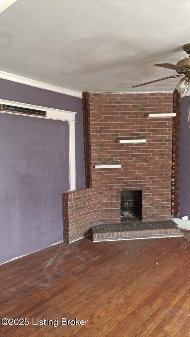 unfurnished living room featuring wood-type flooring, ceiling fan, and a fireplace