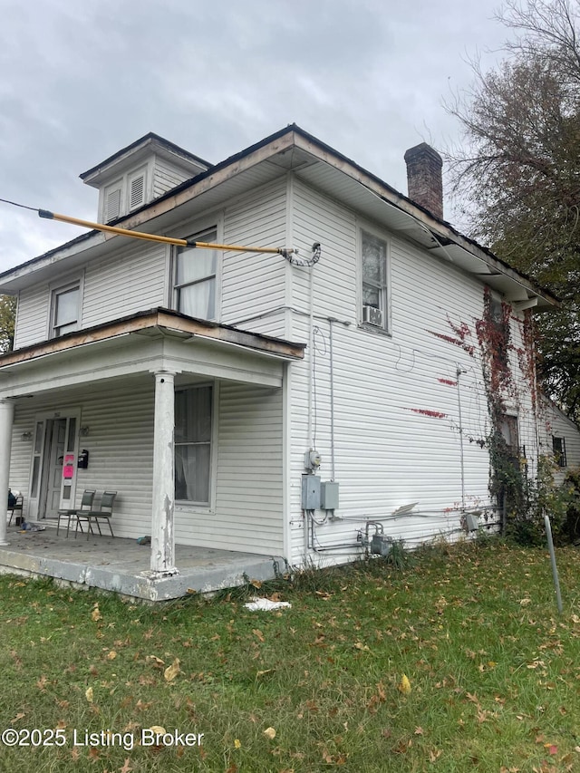 view of home's exterior with a lawn, a patio, and covered porch