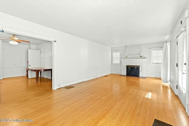 unfurnished living room with hardwood / wood-style floors, a fireplace, and ceiling fan