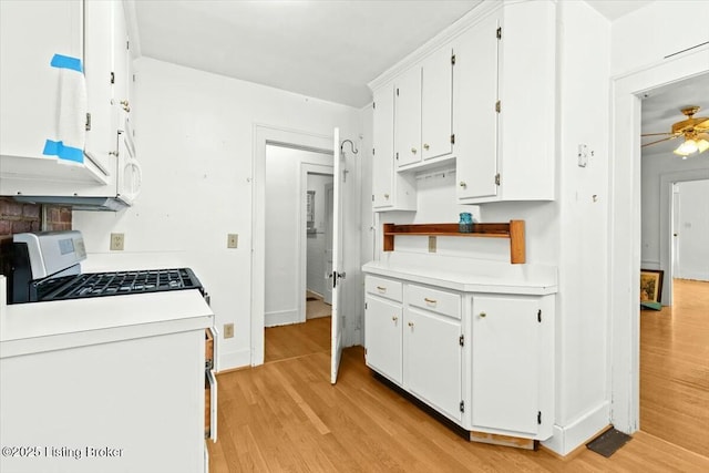 kitchen featuring white cabinetry, ceiling fan, light hardwood / wood-style floors, and stainless steel gas range oven