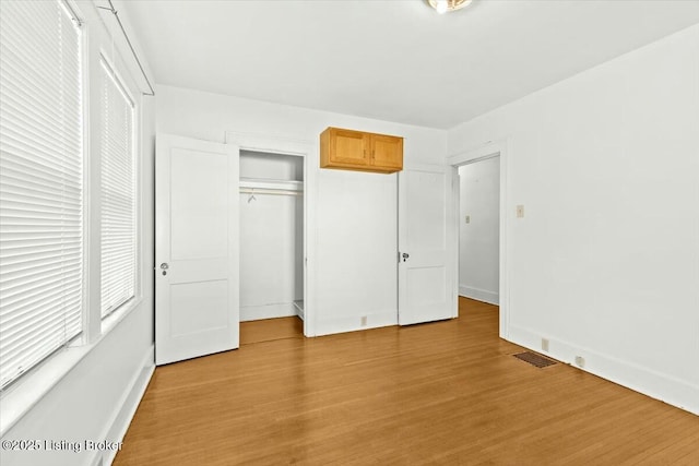 unfurnished bedroom featuring a closet and light wood-type flooring