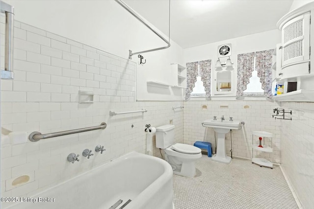 bathroom with sink, tile walls, tile patterned floors, and toilet