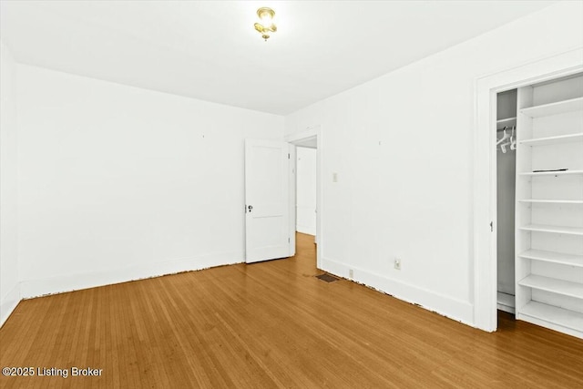 unfurnished bedroom with hardwood / wood-style floors and a closet