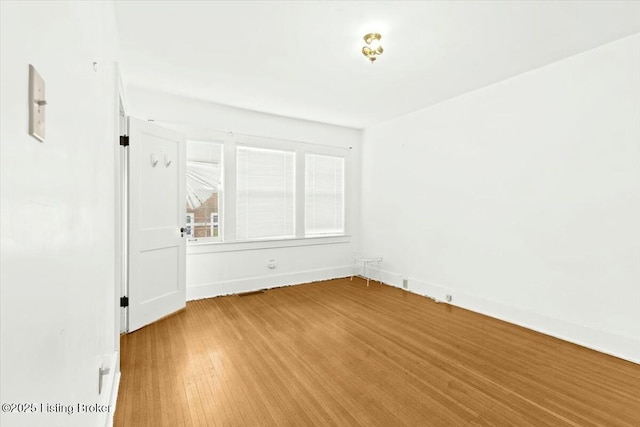 unfurnished room with hardwood / wood-style flooring