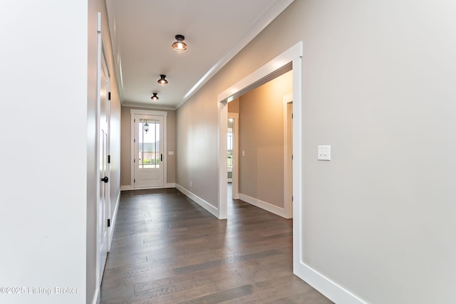 doorway with crown molding and dark wood-type flooring