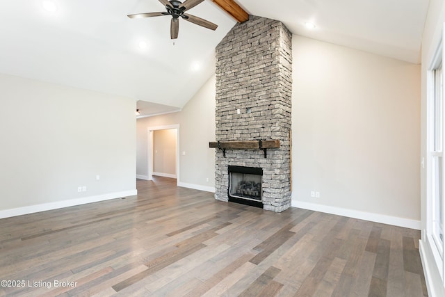 unfurnished living room with high vaulted ceiling, a fireplace, hardwood / wood-style flooring, ceiling fan, and beam ceiling