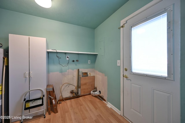 laundry room with baseboards and light wood-style floors