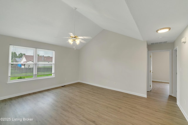 empty room featuring vaulted ceiling, ceiling fan, and light wood-type flooring