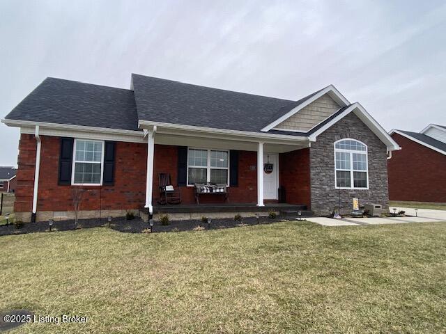 view of front of home with covered porch and a front lawn