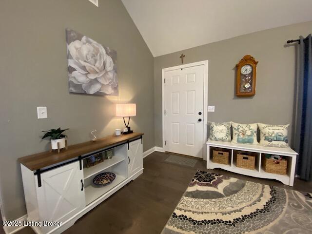 entrance foyer with dark hardwood / wood-style flooring and vaulted ceiling