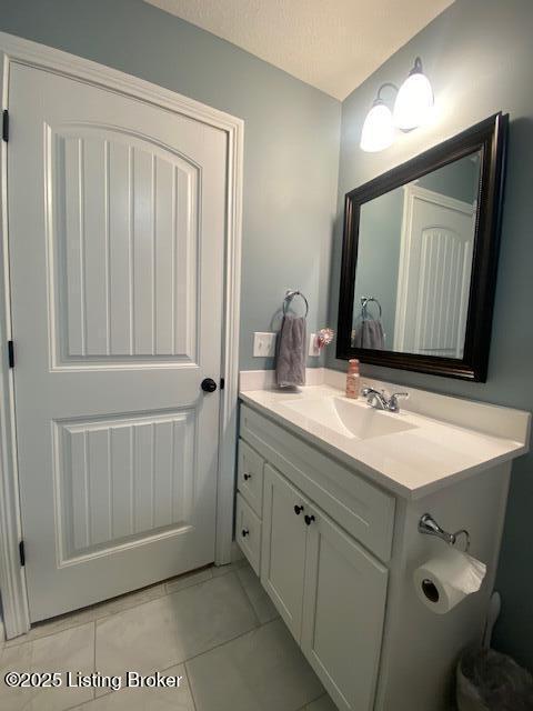 bathroom featuring tile patterned floors, vanity, and a textured ceiling