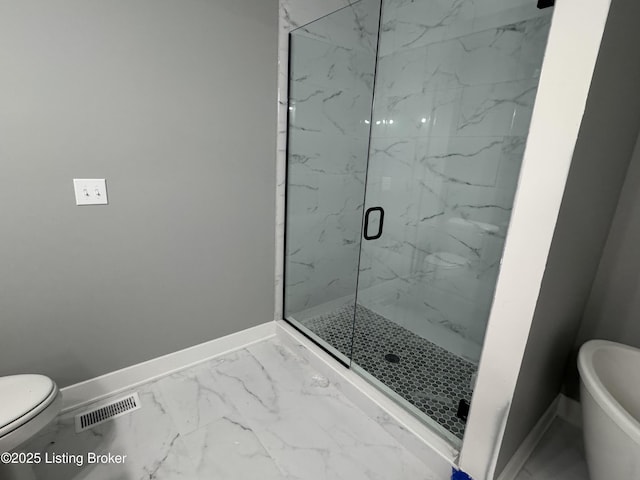 bathroom with a shower with shower door and toilet