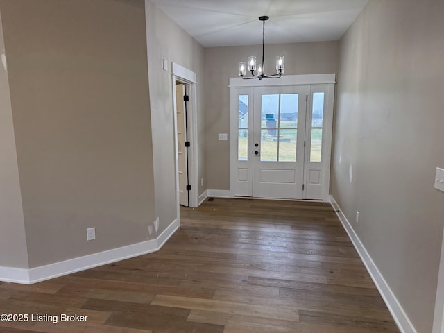 foyer entrance with dark wood-type flooring and a notable chandelier