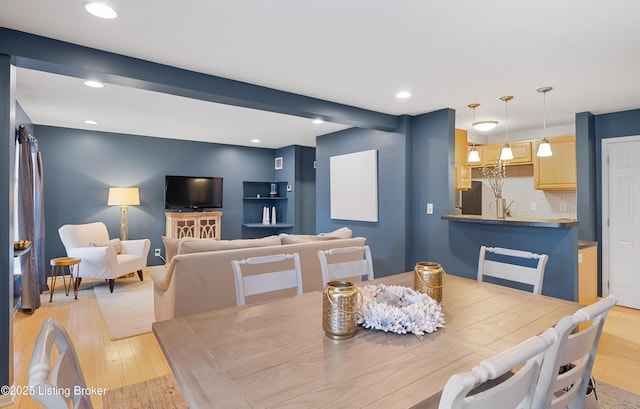 dining area with beamed ceiling and light hardwood / wood-style floors