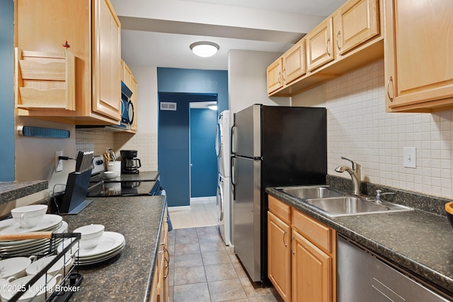 kitchen with dishwashing machine, sink, light tile patterned floors, stainless steel fridge, and backsplash