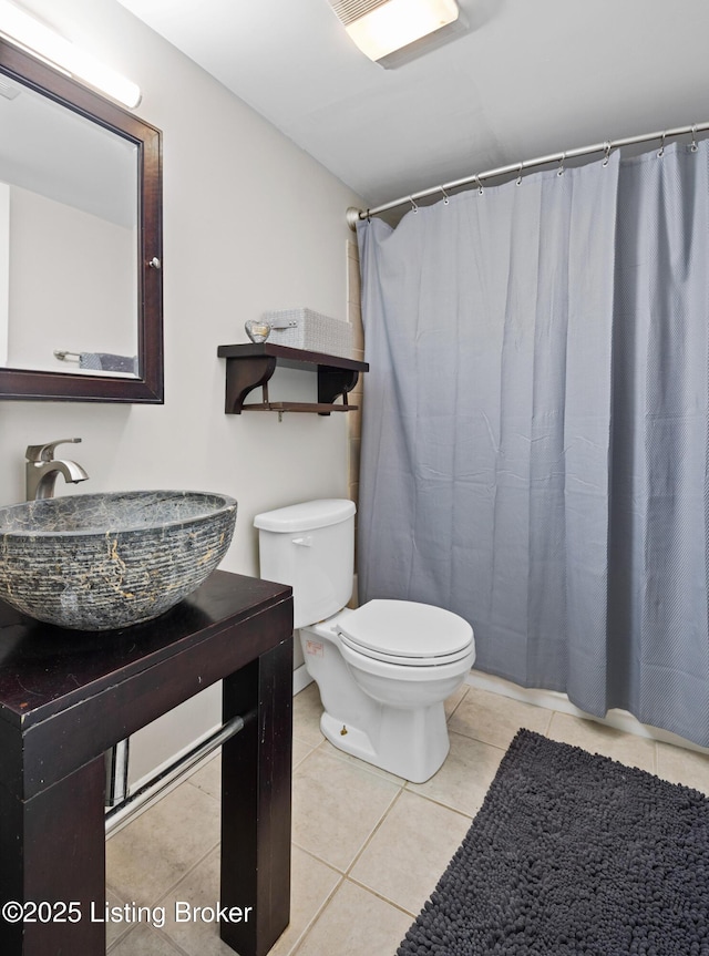 bathroom featuring toilet, tile patterned flooring, and sink