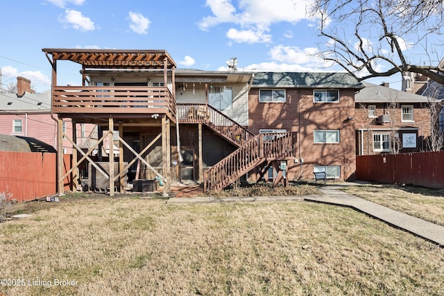 rear view of house with a wooden deck and a yard