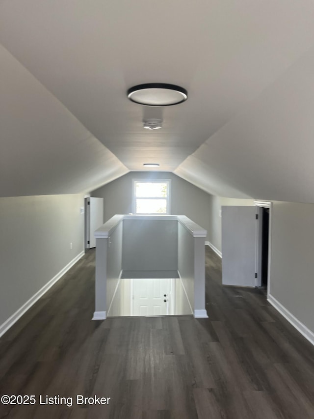 bonus room featuring lofted ceiling, baseboards, and dark wood-style flooring