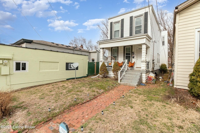 exterior space featuring covered porch and a front yard