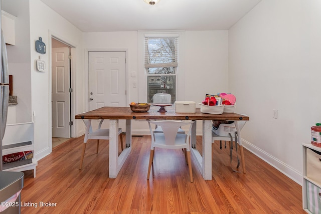 dining room with baseboards and light wood finished floors