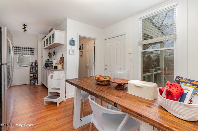 dining area with light wood-type flooring and baseboards