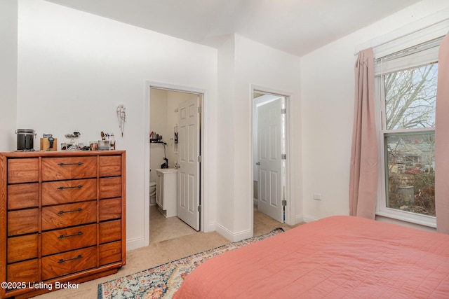 bedroom with light colored carpet and baseboards