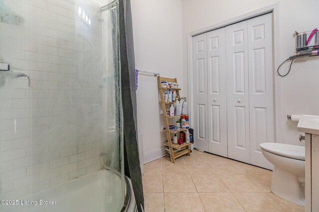 bathroom with shower / bath combination with glass door, toilet, and tile patterned floors