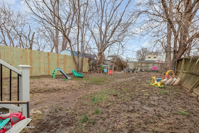 view of yard featuring a playground and a fenced backyard