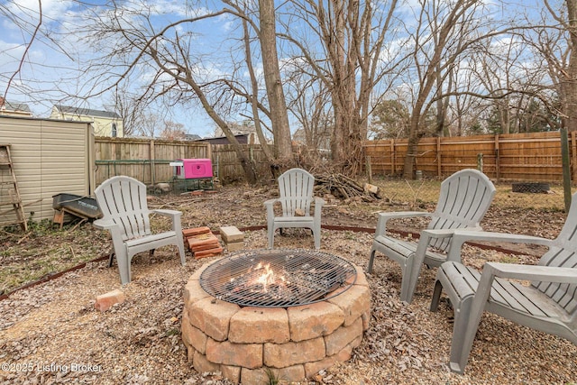 view of yard featuring a fire pit, an outdoor structure, and a fenced backyard