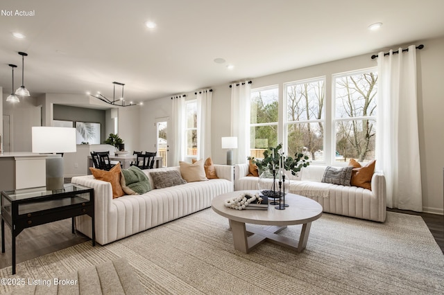 living room with plenty of natural light, a chandelier, and hardwood / wood-style floors