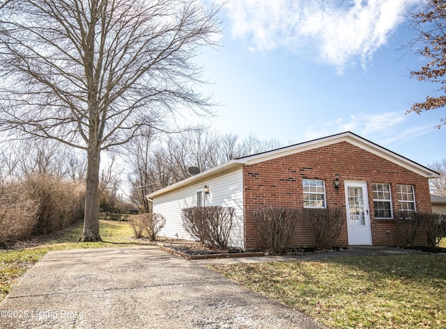 view of home's exterior with a lawn and brick siding