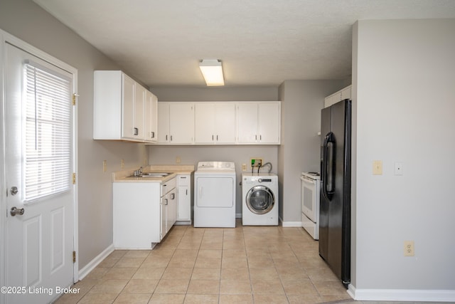 washroom featuring washer and dryer, a sink, baseboards, and light tile patterned floors