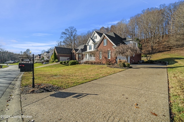 traditional-style home with a residential view, a front lawn, concrete driveway, and brick siding