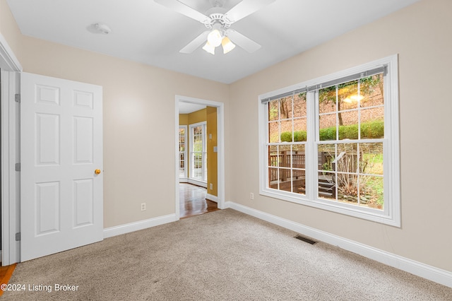 unfurnished room featuring a ceiling fan, baseboards, visible vents, and carpet flooring