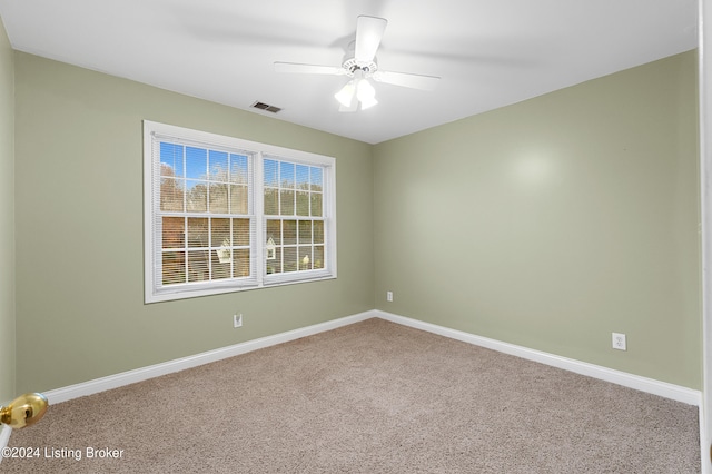 empty room featuring carpet floors, visible vents, baseboards, and a ceiling fan