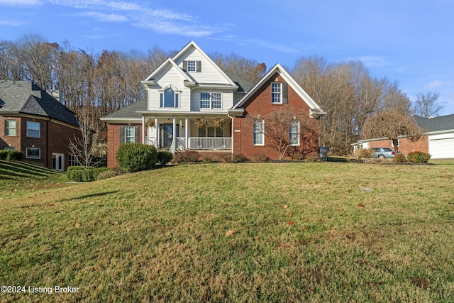 traditional home with a porch, a front yard, and brick siding