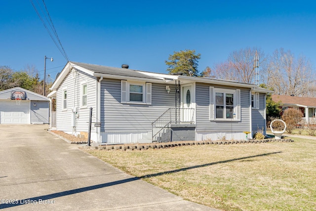 view of front of property featuring a garage, an outbuilding, and a front yard