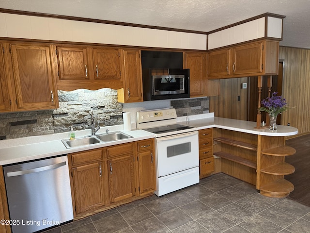 kitchen with sink, ornamental molding, appliances with stainless steel finishes, kitchen peninsula, and decorative backsplash